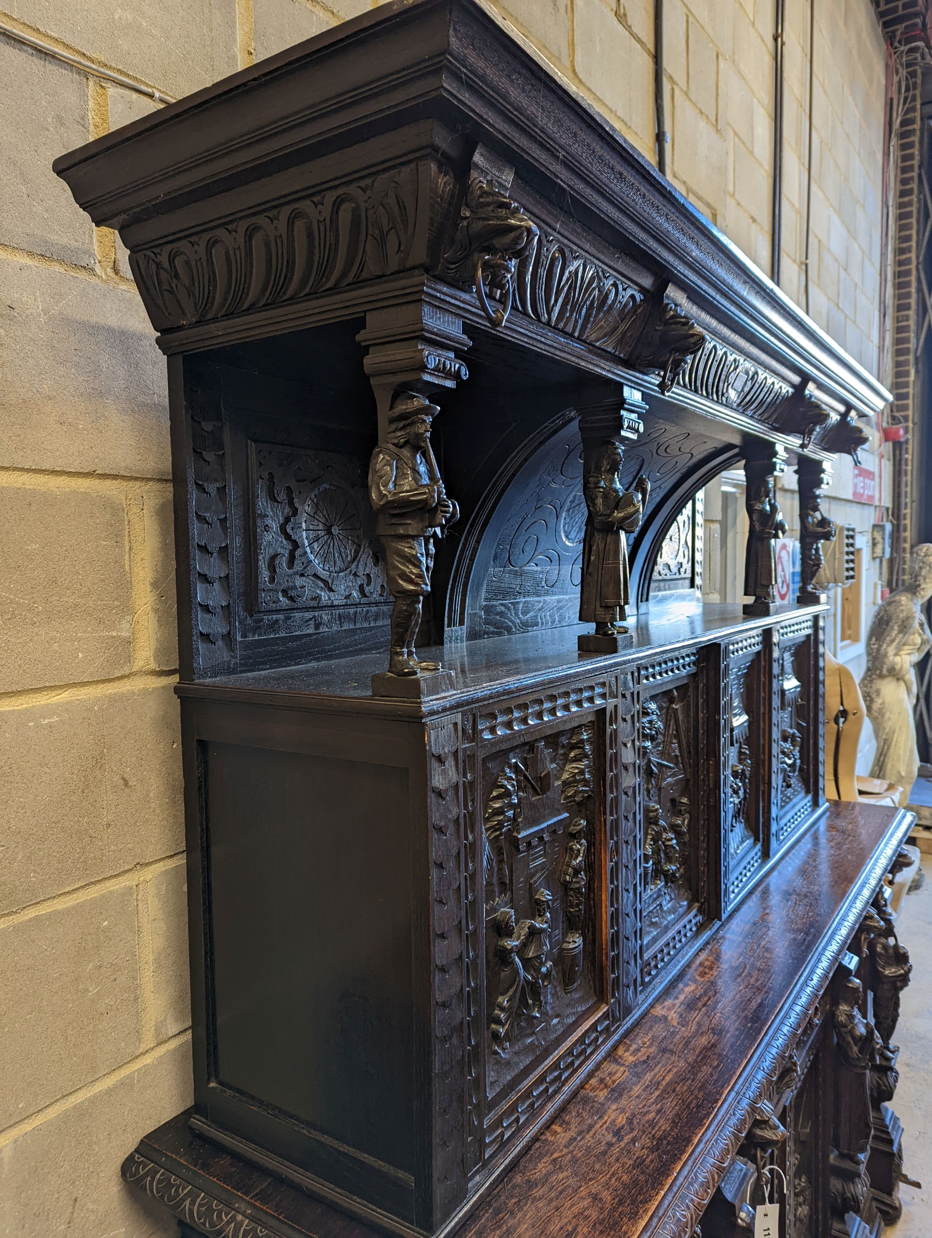 An early 20th century carved oak court cupboard in the Flemish style, length 200cm, depth 58cm, height 212cm